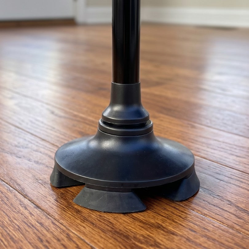 StandSecure standing upright on its own four-point base, beside an armchair